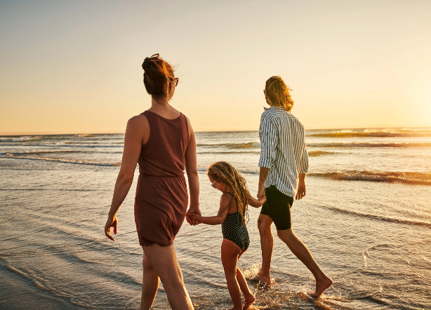 Family walking along the beach at sunsetFamily walking along the beach at sunset